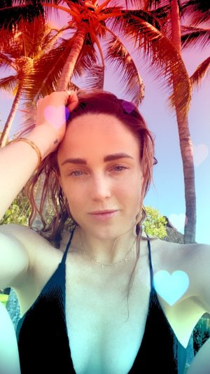 Caity Lotz - taking a selfie in front of some trees 152242605_caity.jpg