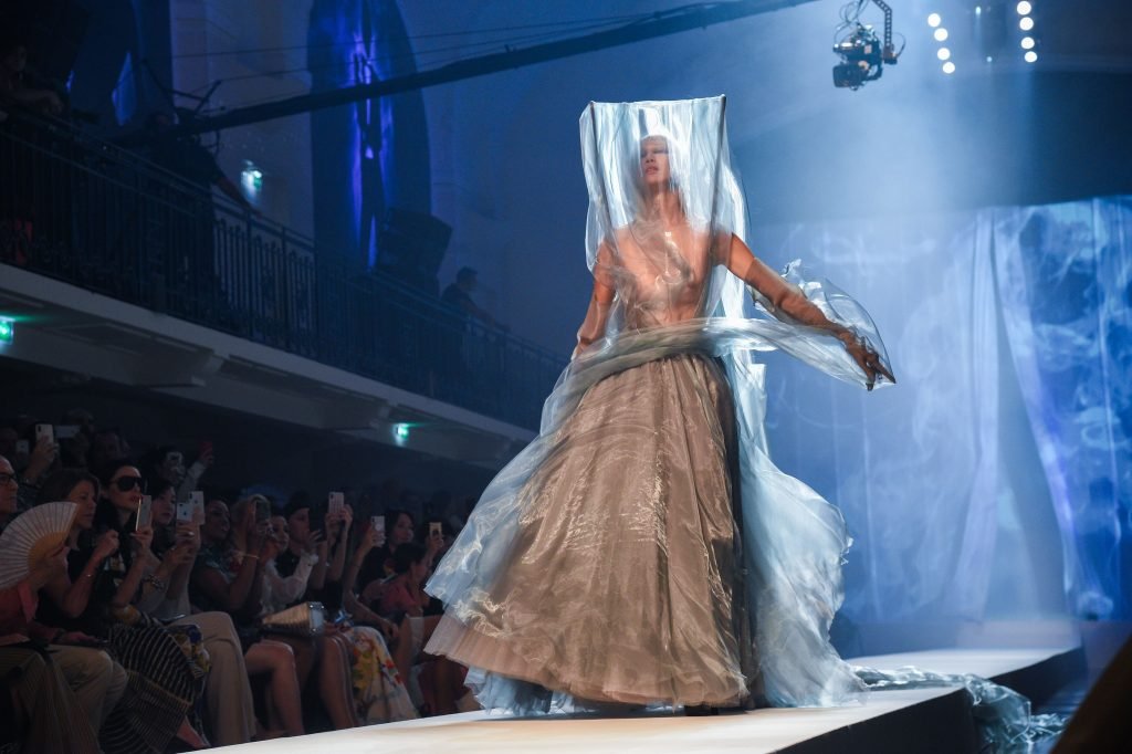 Asian Soo Joo Park walks the runway in a dress with a see-through veil duri...
