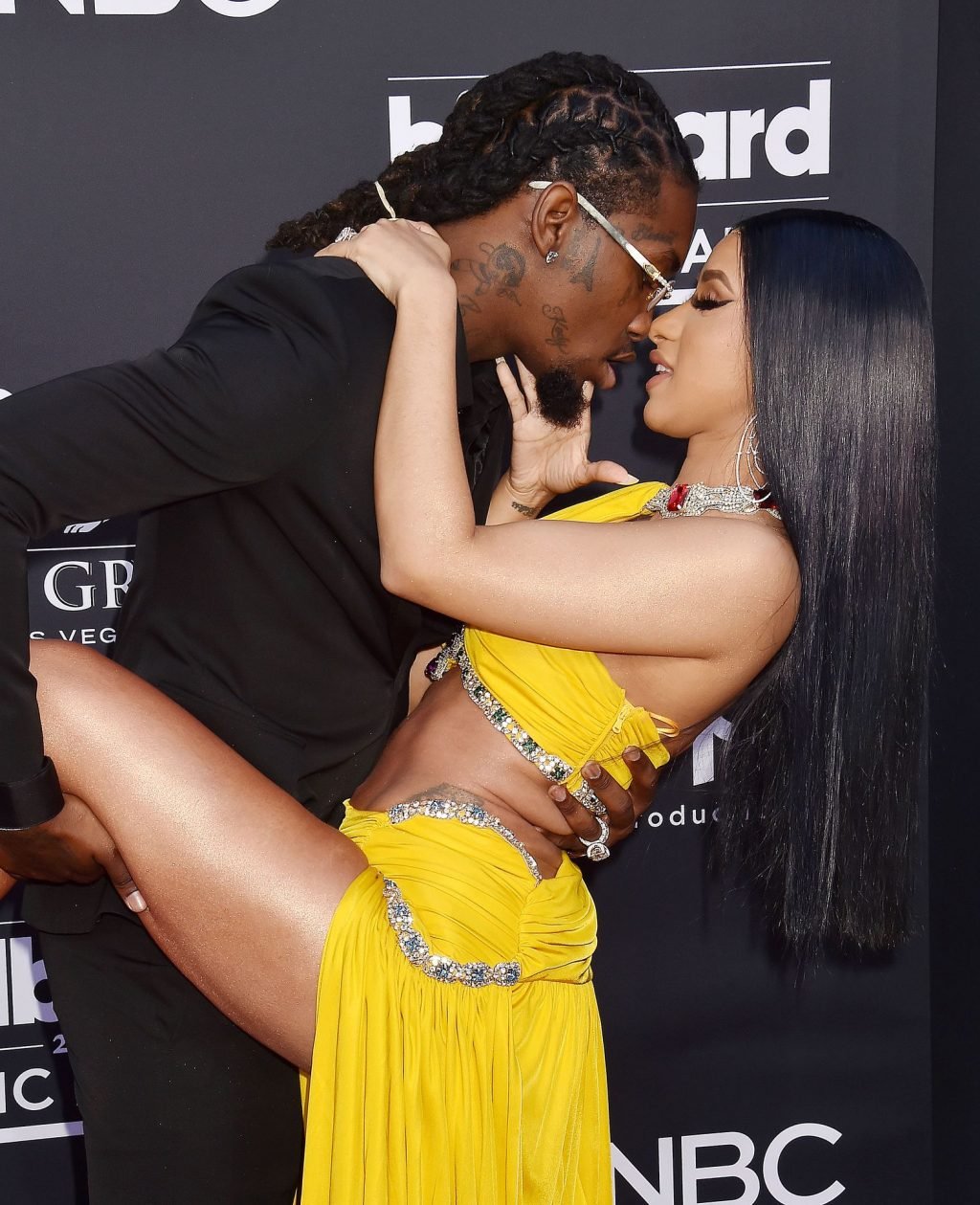 Cardi B wows in a yellow dress on the red carpet kissing with Offset at the...