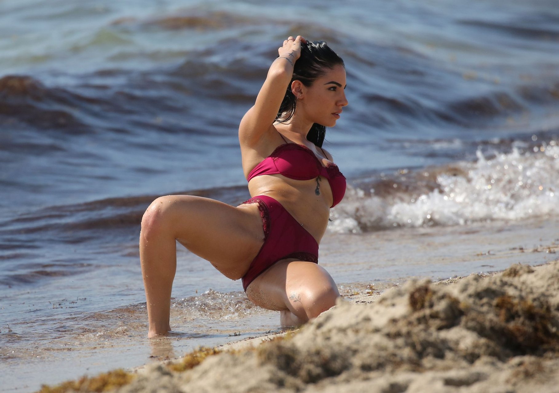 Model Giulia De Lellis wears red bikini and a black one-piece during a phot...