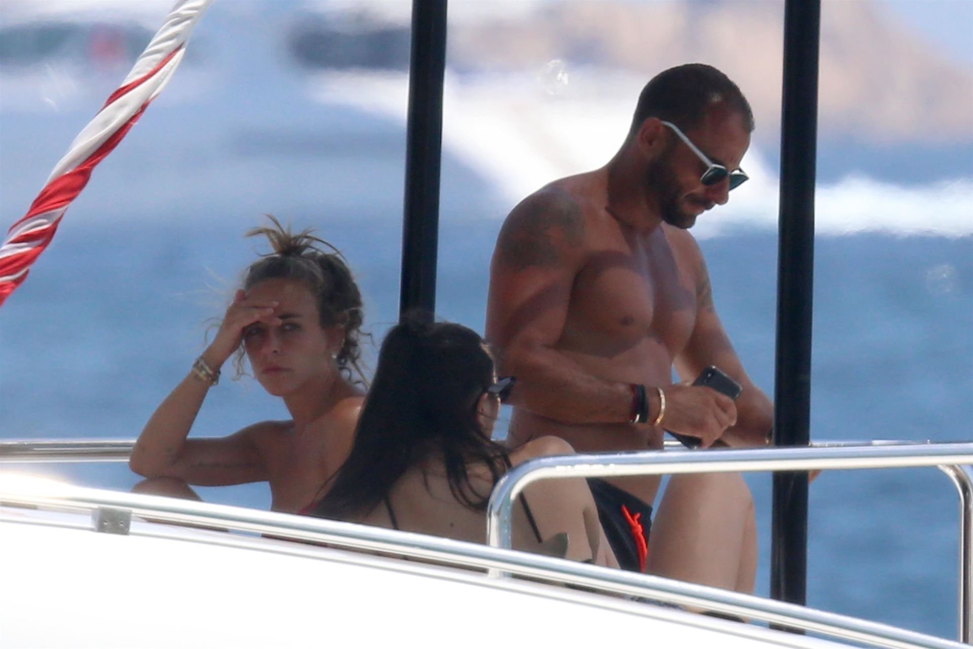 Topless Chloe Green and an unknown man get close while relaxing on her fath...