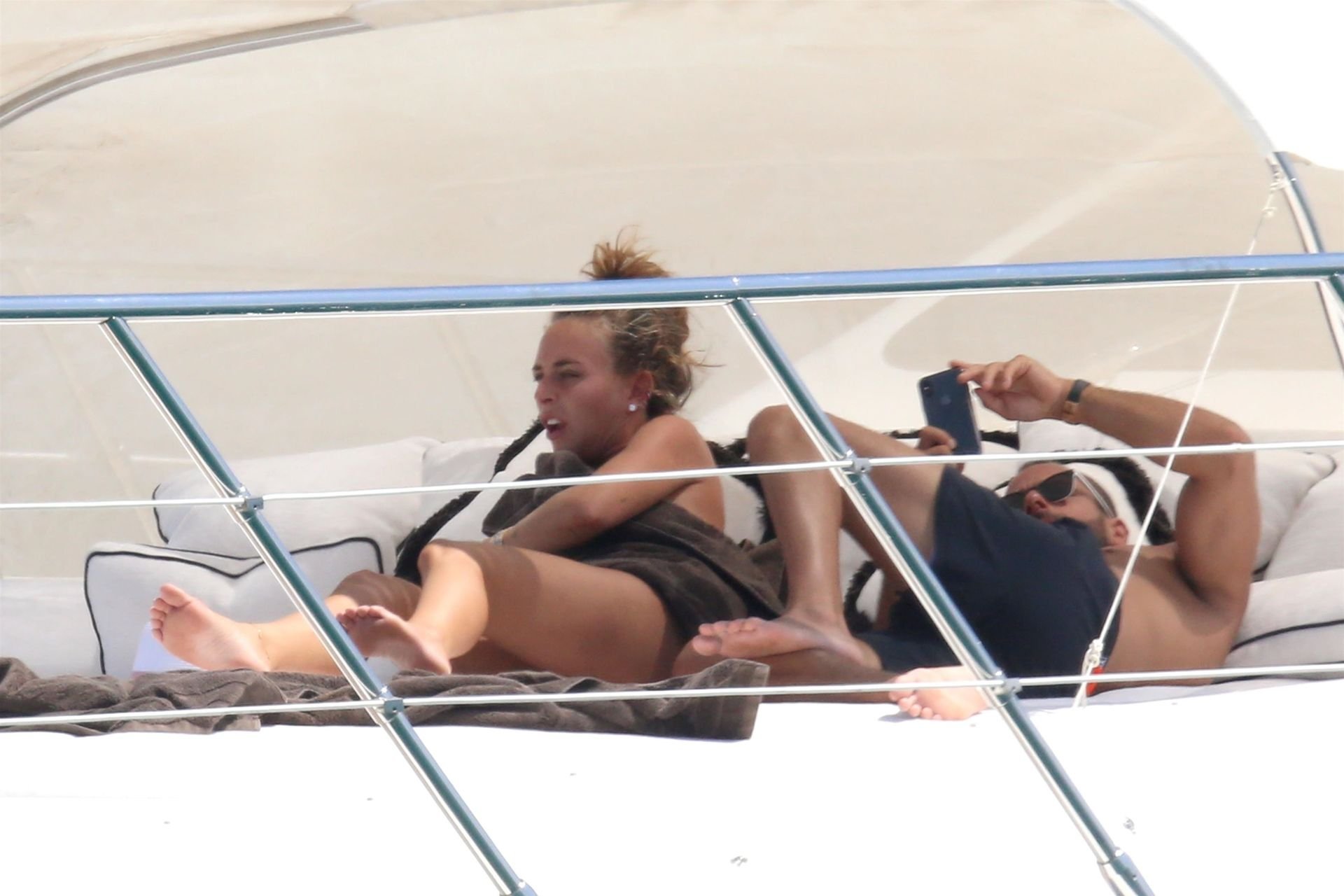 Topless Chloe Green and an unknown man get close while relaxing on her fath...