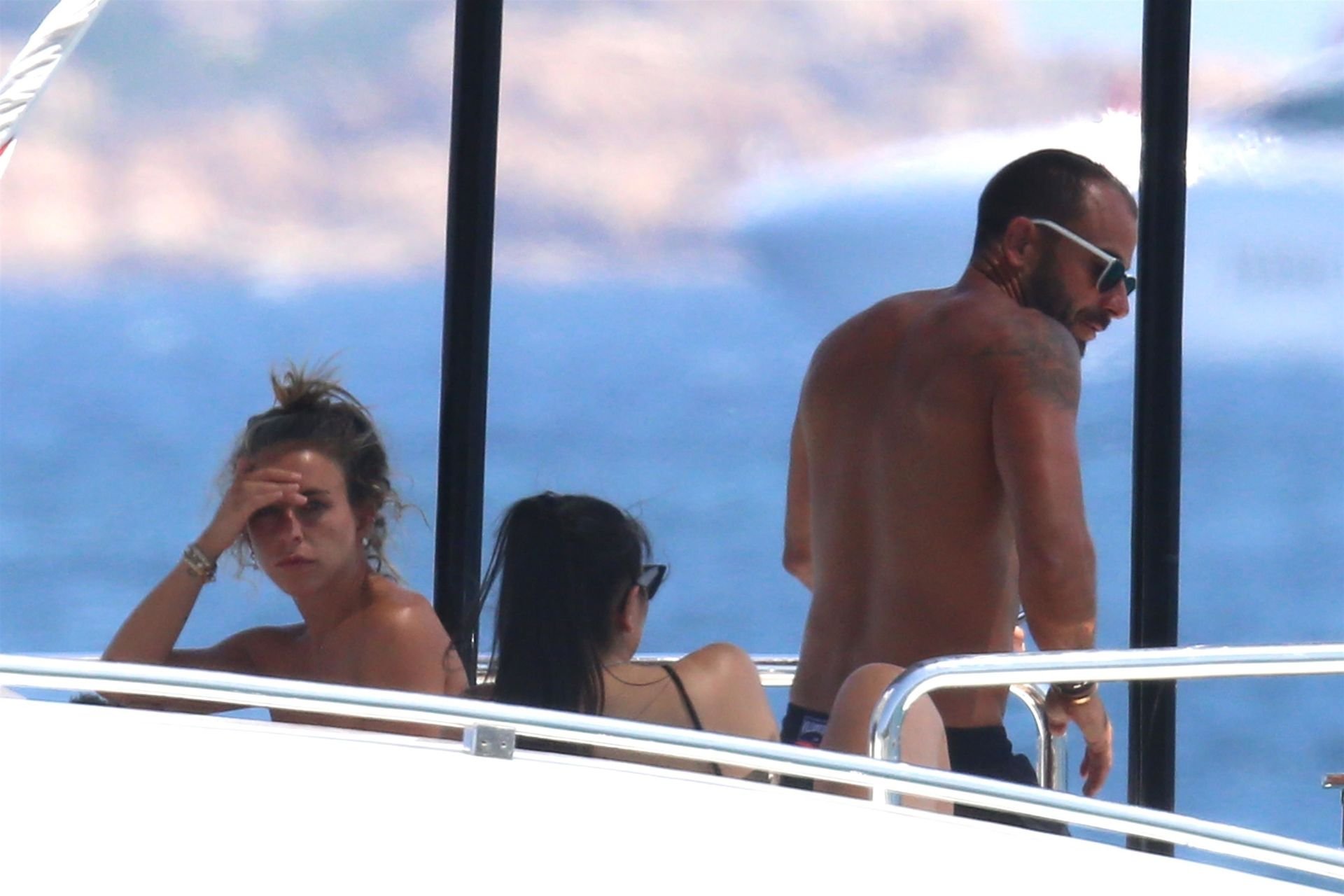 Topless Chloe Green and an unknown man get close while relaxing on her fath...