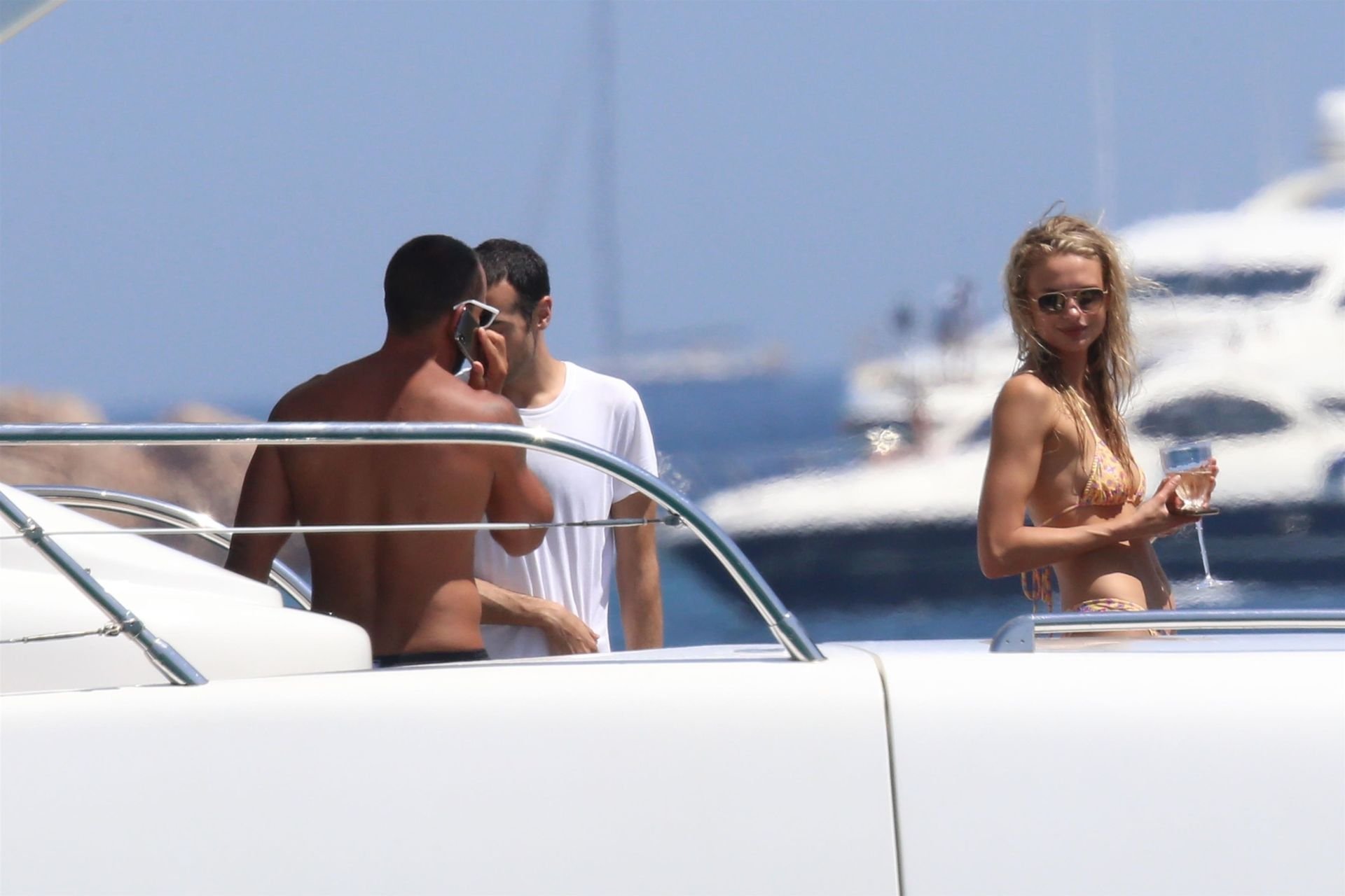 Topless Chloe Green and an unknown man get close while relaxing on her fath...