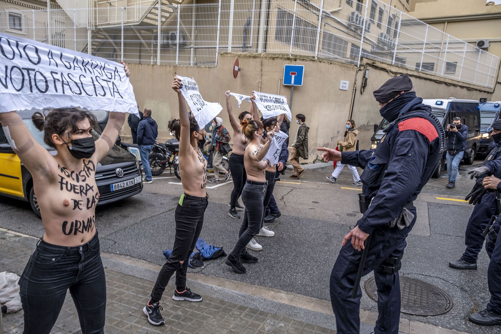 Topless Femen activists hold banners in front of the La Salle Bonanova duri...