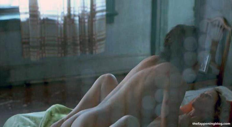 Vera Farmiga sits up in bed, resting on a male, her naked breasts showing t...