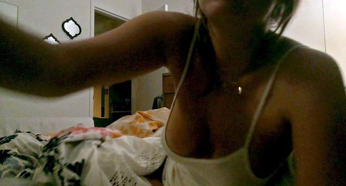 She reaches for her phone several times, exposing her cleavage, all while a...