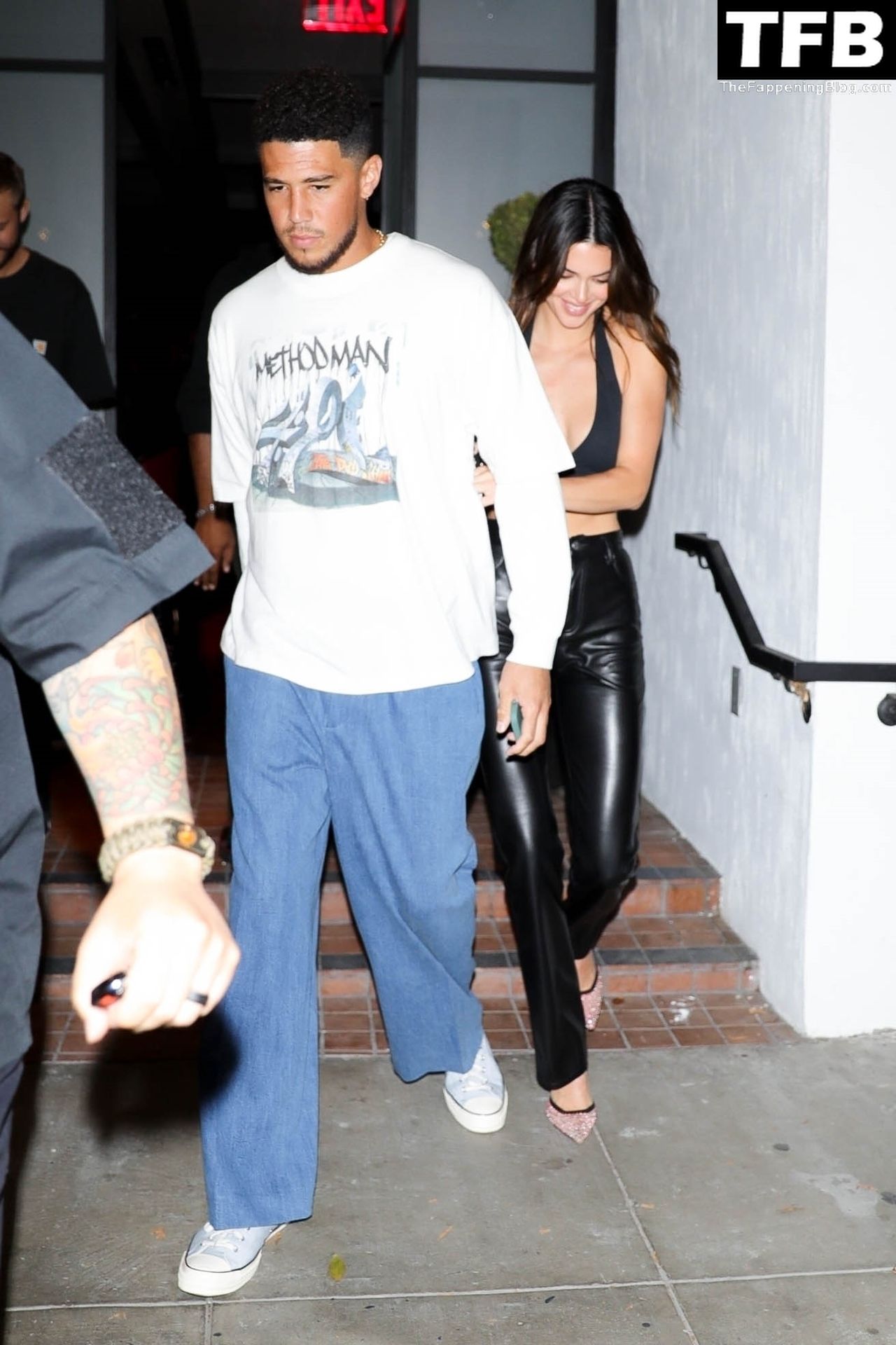Kendall Jenner and her boyfriend Devin Booker are surrounded by security as...